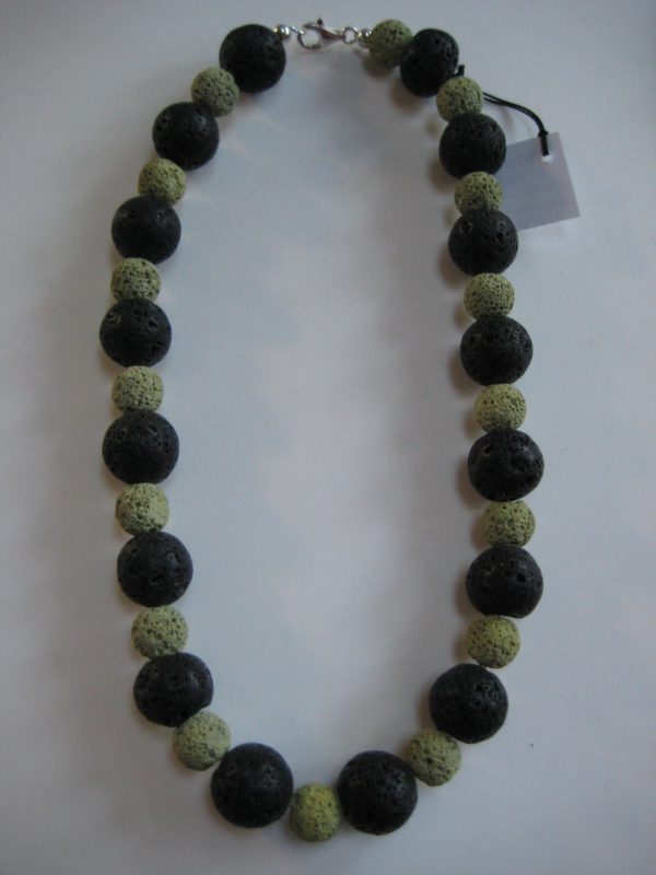 Eine Edelsteinkette aus Lavastein mit grünen und schwarzen Steinen aufgelegt.