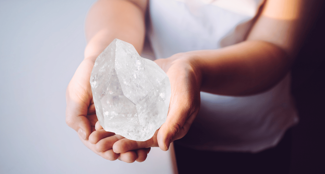 Frau hält wunderschönen Bergkristall in Händen.