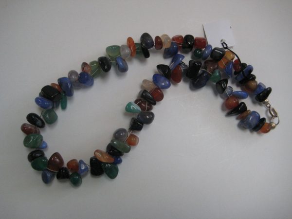 Aufgelegte Edelsteinkette aus Achatnuggets. Die Farben der Nuggets reichen von braun über grün bis hin zu blau schimmernd.