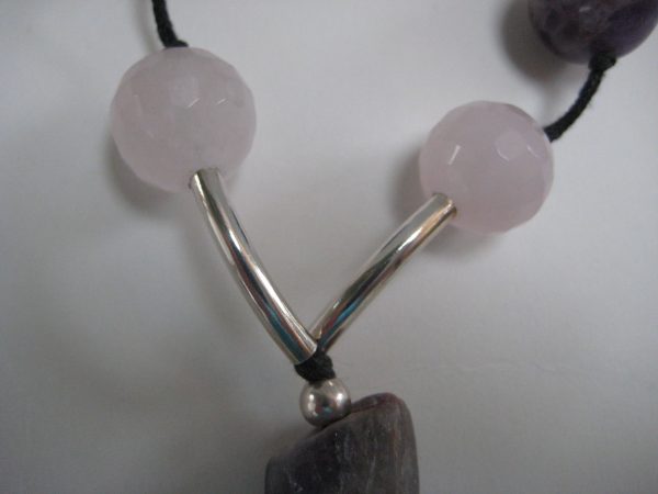 Zoom auf zwei Rosenquarzkugeln und silberne Zwischenteile einer Edelsteinkette aus Amethyst, Bergkristall und Rosenquarz.