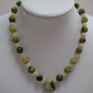 Grün schimmernde Edelsteinkette aus Aragonit und Serpentin auf einer weißen Damenbüste.