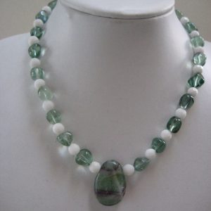 Edelsteinkette aus Fluorit und Jade auf einer weißen Büste.