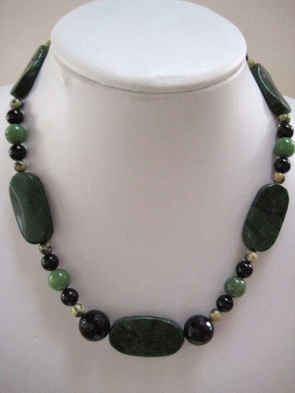 Eine Edelsteinkette aus Jade, Serpentin und Turmalin auf einer weißen Damenbüste.