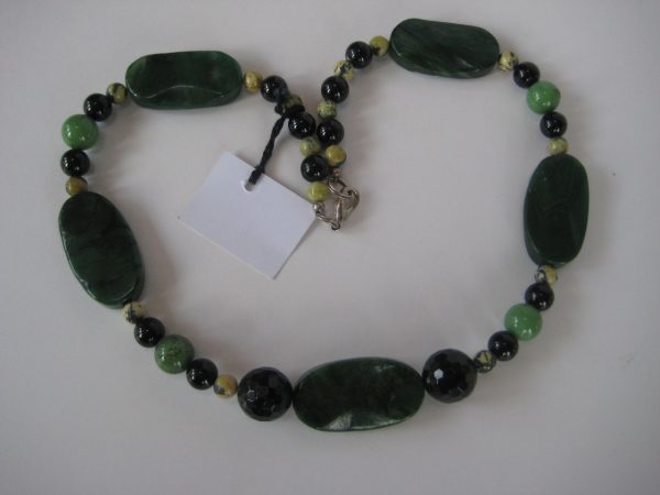 Zu einem Herz gelegte Edelsteinkette aus Jade, Serpentin und Turmalin.