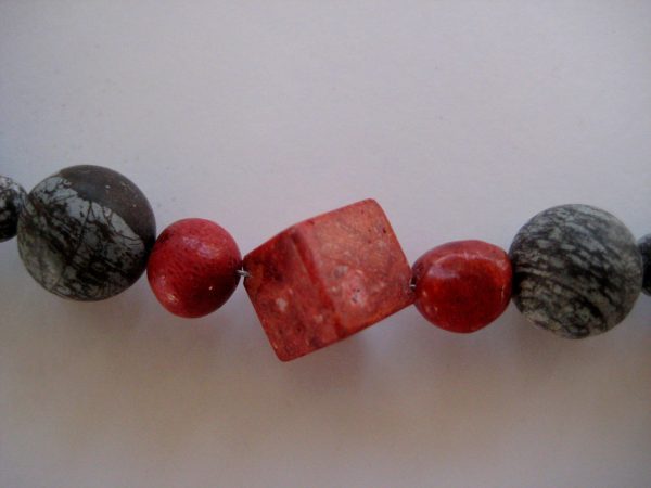 Fokus auf die roten Schaumkoralle-Steine der Edelsteinkette aus Koralle und Achat.