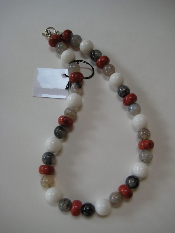 Aufgelegte Edelsteinkette aus Koralle, Jade und Achat in Rot-, Weiß-, Grau-, und Schwarztönen.