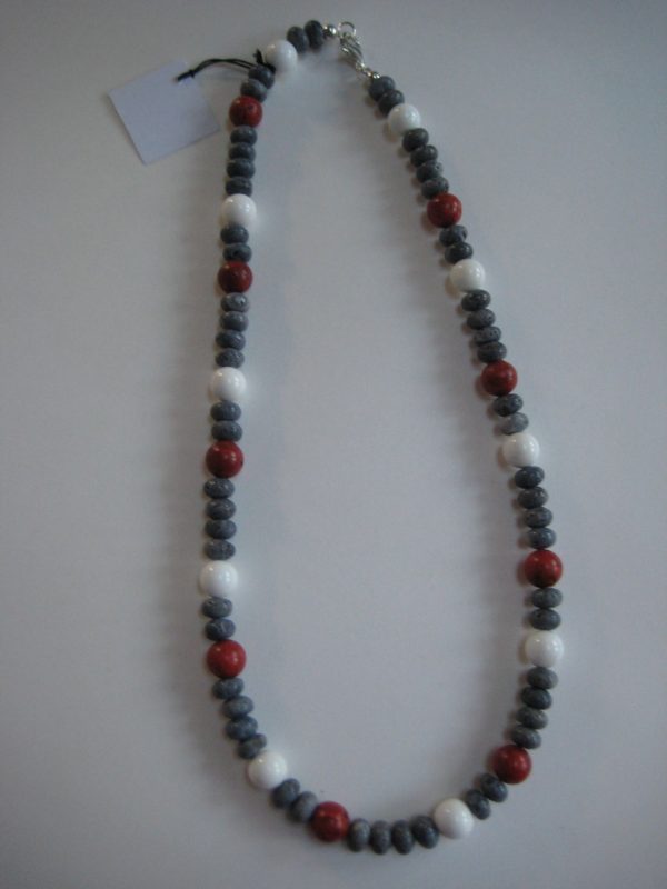 Aufgelegte Edelsteinkette aus Koralle und Jade mit roten, blauen und weißen Steinen.