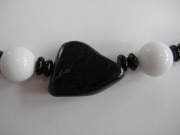 Der schwarze Onyx-Mittelstein einer Edelsteinkette aus Onyx und Jade.