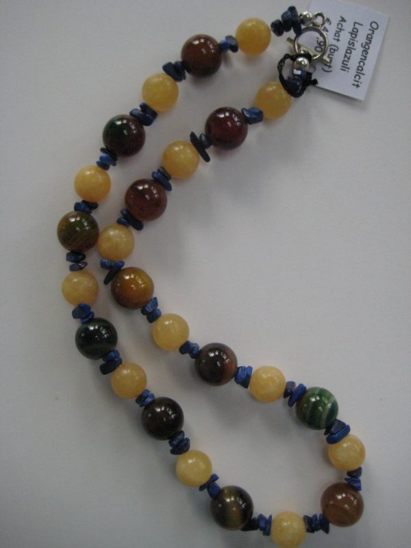 Aufgelegte Edelsteinkette aus Orangencalzit, Lapislazuli und Achat. Die Farben reichen von Gelb bis hin zu Brauntönen.