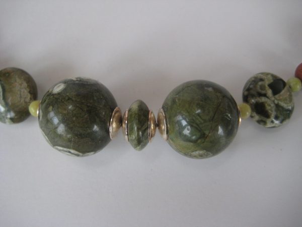 Zoom auf die einzelnen grünen Steine einer Edelsteinkette aus Rhyolith, Goldfluss und Chyta.