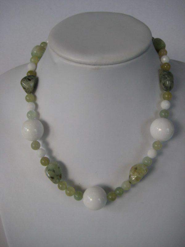 Eine Edelsteinkette aus Jade, Prehnit und Serpentin in frühlingsfrischen grünen Farben auf einer weißen Damenbüste.